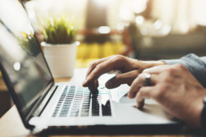 male hands typing on laptop