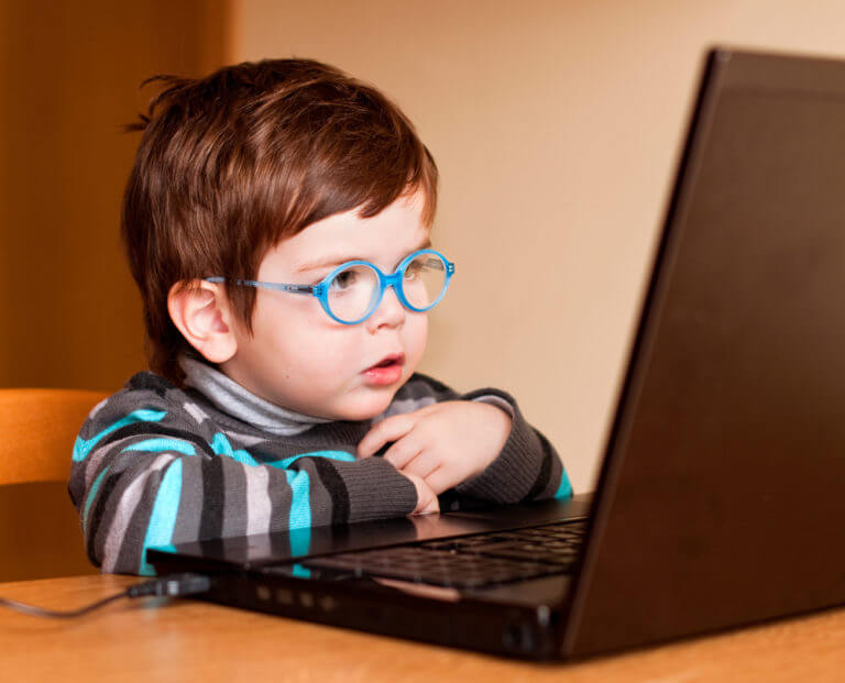 young boy with glasses at laptop