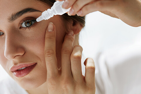 Woman putting in eye drops